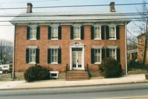 Color photo of front of red brick Creeger House.