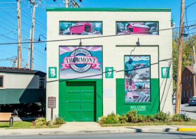 White building with green paint and murals.