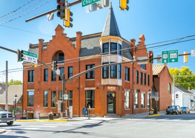 View across an intersection of brick building with steeples on roof