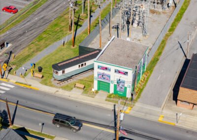 Aerial view of white building with murals and trolley car