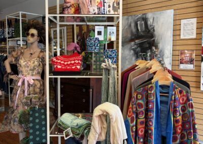 Interior of current business showing a display case and clothes on a display rack.